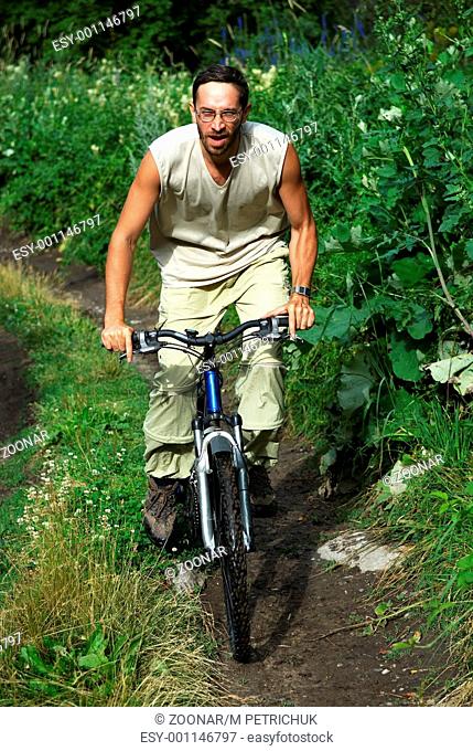 Mountain biker on old rural road in forest