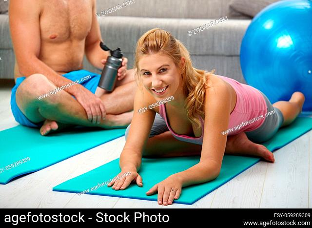 Young women doing streching exercise lying on fitness mat
