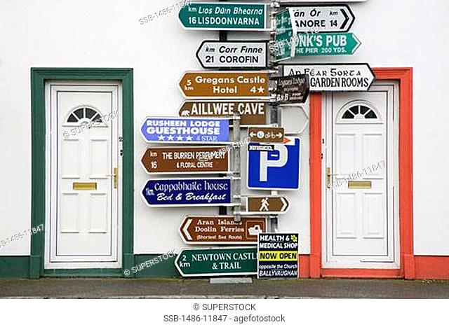 Directional signs in front of a building, Ballyvaughan, The Burren, County Clare, Munster Province, Republic of Ireland