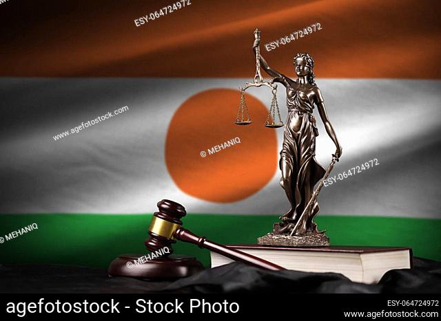 Niger flag with statue of lady justice, constitution and judge hammer on black drapery. Concept of judgement and punishment