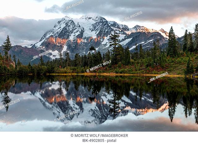 Sunset, Mt. Shuksan glacier with snow reflected in Picture Lake, wooded mountain landscape, Mt. Baker-Snoqualmie National Forest, Washington, USA