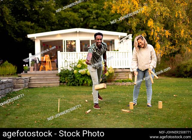 Man and woman playing molkky game in park