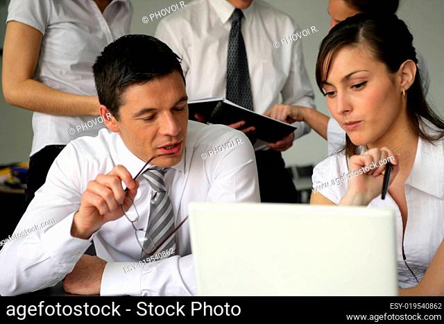man and woman in front of laptop at the office