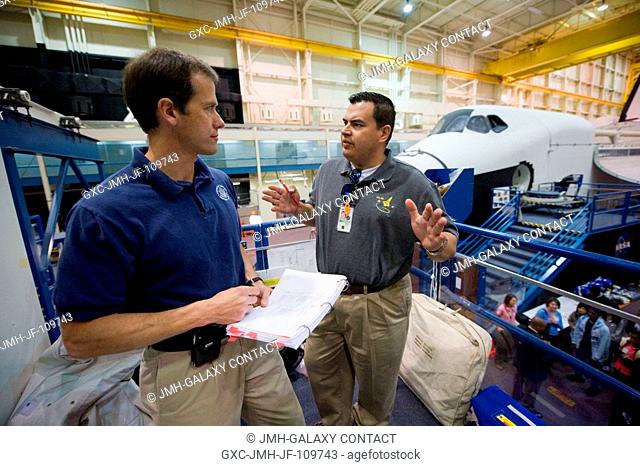 Astronaut Tom Marshburn (left), STS-127 mission specialist, and United Space Alliance trainer Joe Leal discuss training activities in the Space Vehicle Mock-up...