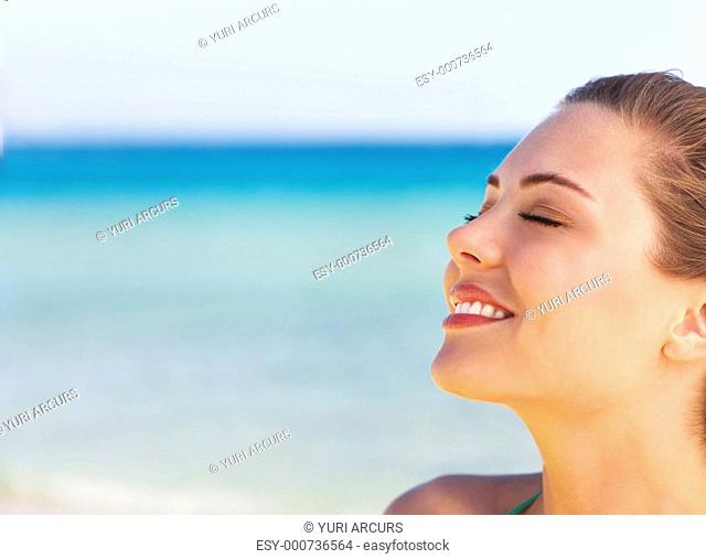 A beautiful young woman taking in the sun at the beach in Greece