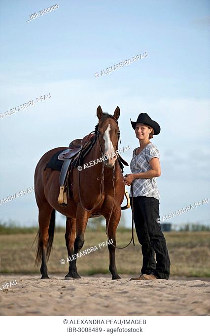 Woman standing next to a Quarter Horse