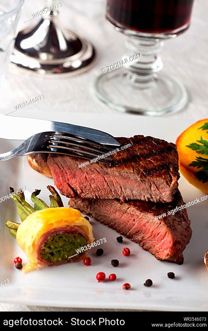Steak mit Speckbohnen auf einem Teller