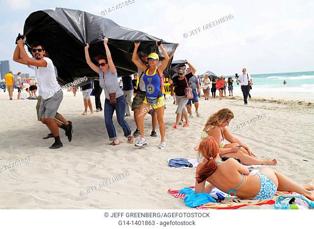 Florida, Miami Beach, oil spill protest, offshore drilling, black plastic sheet represents slick, Atlantic Ocean, Hispanic, man