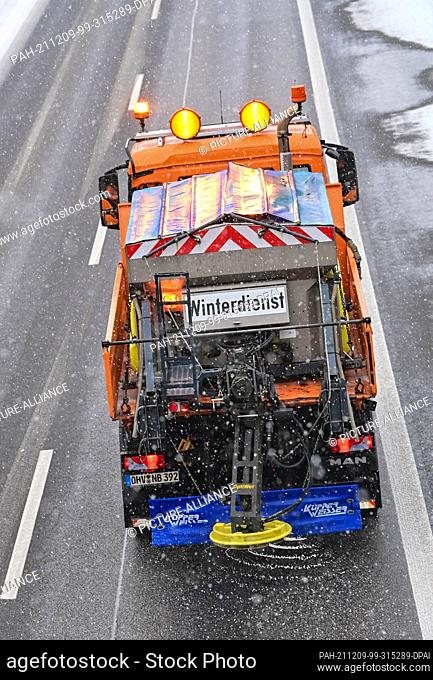 09 December 2021, Brandenburg, Jacobsdorf: A vehicle from the Autobahnmeisterei winter service spreads road salt on a carriageway on the A12 motorway