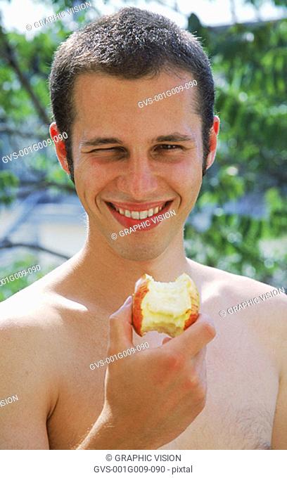 Young man holding an apple core