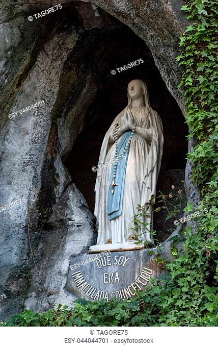 Lourdes, France; August 2013:The rock cave at Massabielle with the statue of the Virgin Mary where Saint Bernadette Soubirous claimed to have witnessed Marian...