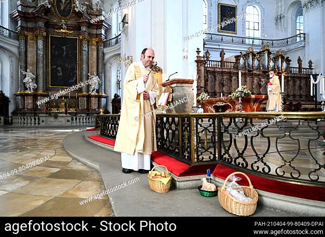 04 April 2021, Baden-Wuerttemberg, Weingarten: Dean Ekkehard Schmid consecrated three Easter baskets filled with Easter eggs or baked Easter lambs in the...