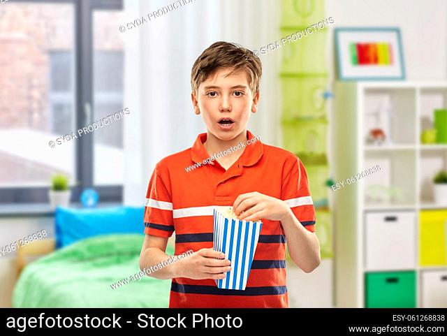 boy eating popcorn at home