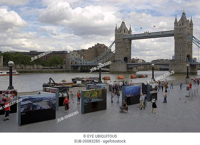 The Queens walk open air exhibition outside the GLA city hall with Tower Bridge behind