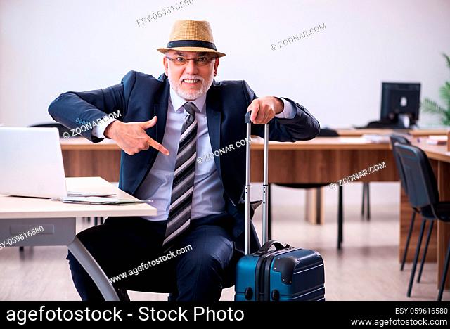 Aged male employee preparing for travel in the office