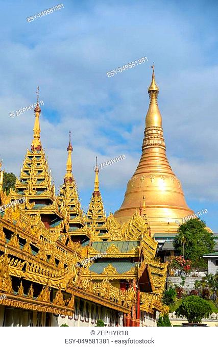 Burmese architecture with traditional ornate roof in front of golden Shwedagon Pagoda, Landmark and travel destination of Yangon, Myanmar