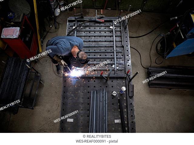 Metal construction, welder welding railing