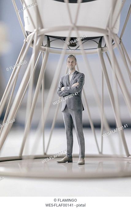 Miniature businessman figurine standing inside structure under VR glasses