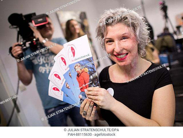 Acid victim Vanessa Muenstermann holds up flyers at a press conference on the founding of her association 'AusGezeichnet' in Hanover, Germany, 15 February 2017