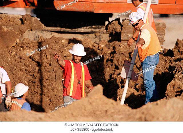 Constructor supervisor and workers in trench. Texas. USA