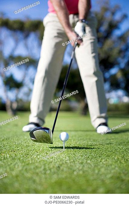 Close up of golf club about to hit golf ball