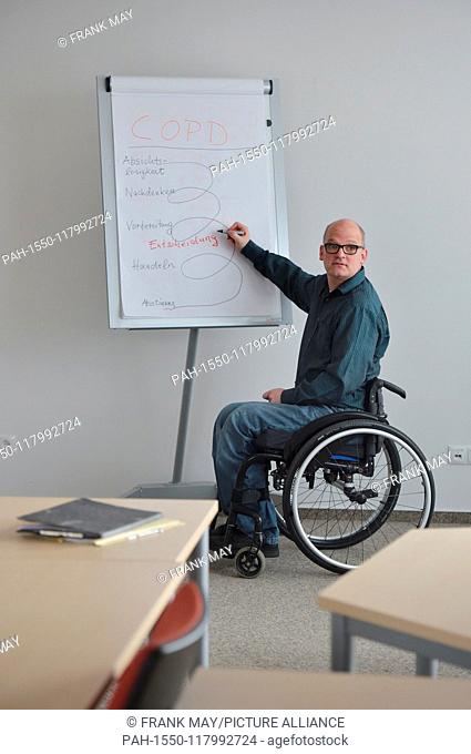 A wheelchair user at his workplace, Germany, city of Hamburg, 05. March 2019. Photo: Frank May (model released) | usage worldwide