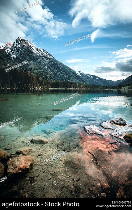 Amazing morning scenery on Hintersee Lake with alpine peaks reflected on the water during spring time