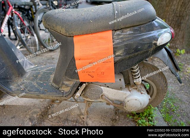 02 May 2022, Hamburg: A red notice from the Hamburg district office is attached to a derelict motor scooter in the Winterhude district