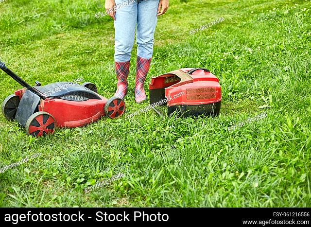 unrecognizable Woman with a lawn mower grass at home garden, gardener woman working, Beautiful summer landscape, sunlight, great design for any purposes
