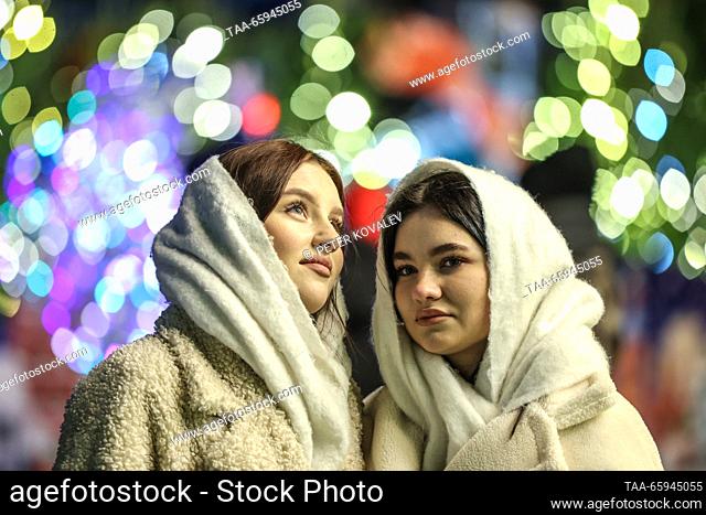 RUSSIA, ST PETERSBURG - DECEMBER 20, 2023: Young women enjoy a ceremony to light up the main Christmas tree of St Petersburg in Palace Square