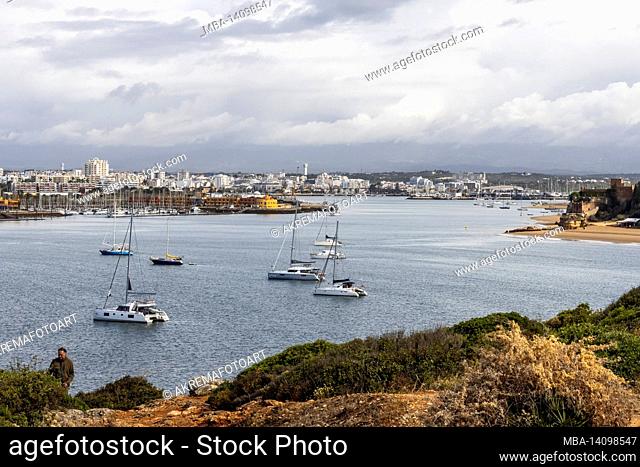 view of the city of portimao with a bay and sailing yachts in the foreground, portugal, algarve, faro district