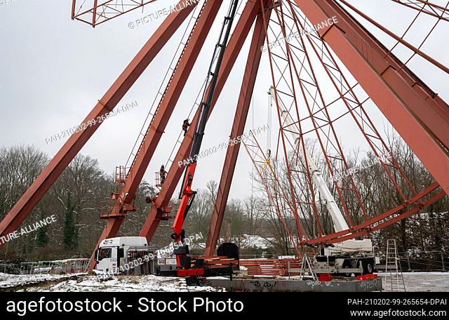 02 February 2021, Berlin: The Ferris wheel at Spreepark is being dismantled for refurbishment. A special company is using several cranes to dismantle the crown...