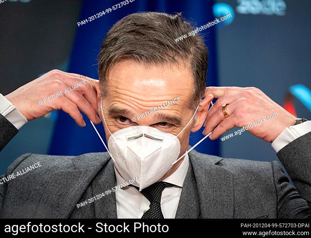 04 December 2020, Berlin: Heiko Maas (SPD), Foreign Minister, puts on his mouth and nose cover after the press conference at the end of the Council of Ministers...