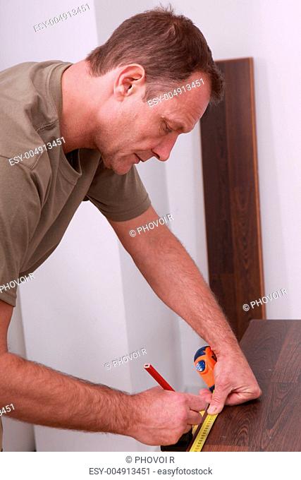 Man measuring laminate flooring