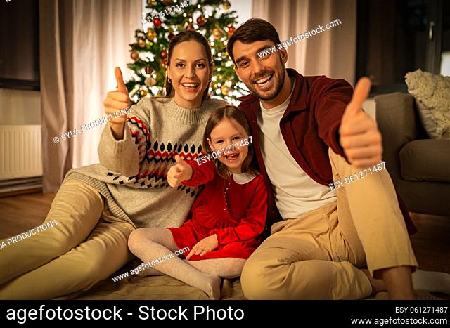 happy family shows thumbs up at home on christmas