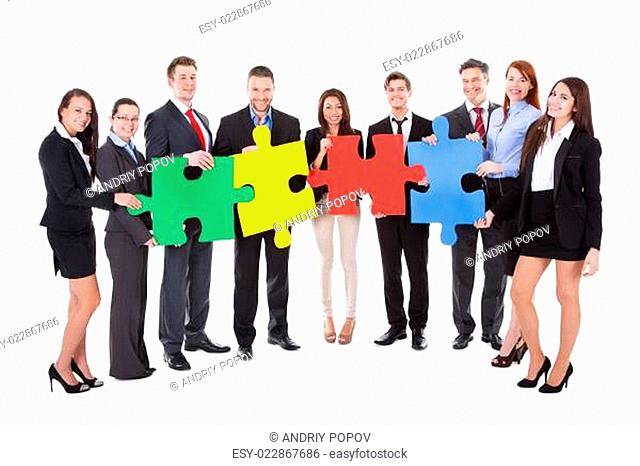 Group of businesspeople holding puzzle pieces