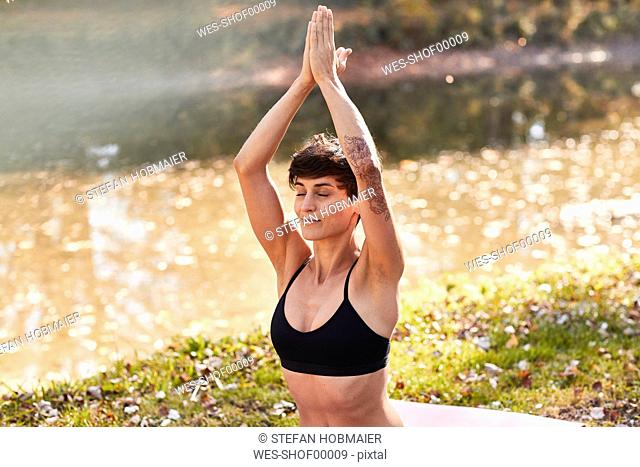 Mid adult woman in forest practicing yoga, meditation