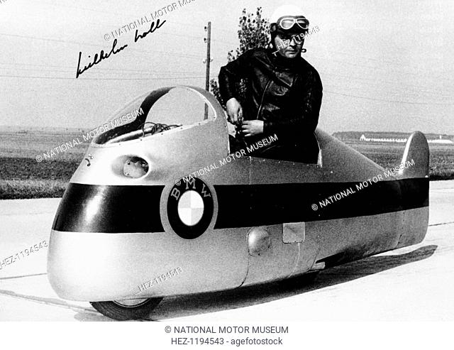 Wilhelm Noll on a 500cc BMW motorcycle, 1955. His signature can be seen in the top left corner. Noll set a world speed record of 280 kph on 4th October 1955