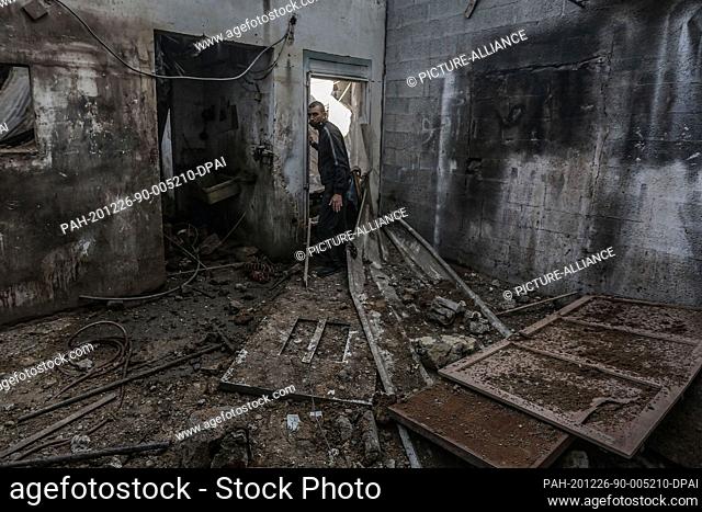 26 December 2020, Palestinian Territories, Gaza City: A Palestinian man inspects the damage at a workshop, after Israeli warplanes carried out airstrikes on the...