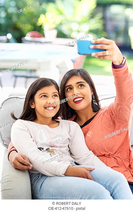 Mother and daughter taking selfie with camera phone