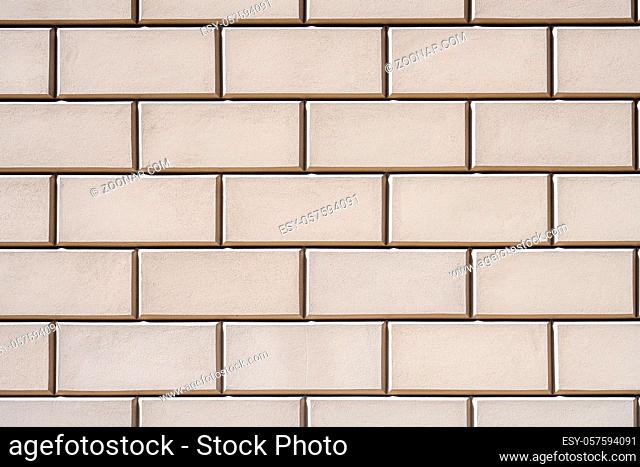 Hintergrund aus einer Wand mit rechteckigen beigen Steinplatten