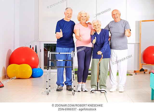 Glückliche Senioren halten gemeinsam die Daumen hoch bei der Physiotherapie