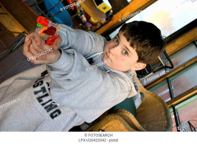 Boy age 8 aiming colorful toy cap gun