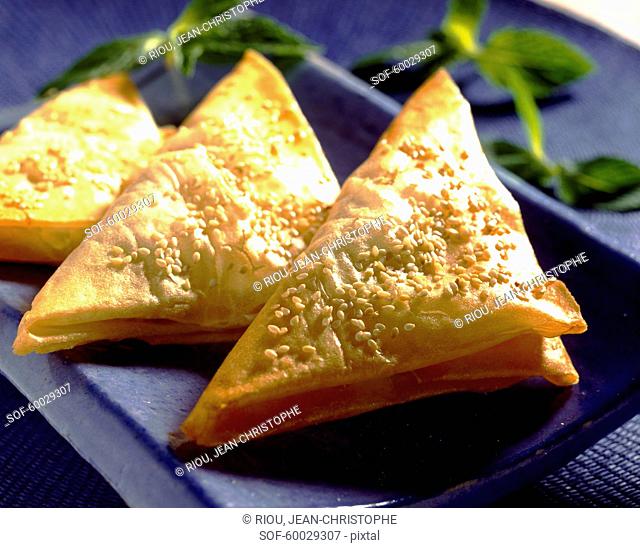 Individual cheese puff pastry pies with sesame seeds