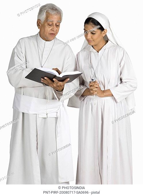 Priest and a nun looking at the Bible