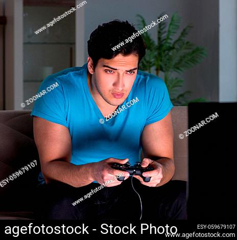 The young man playing computer games late at night