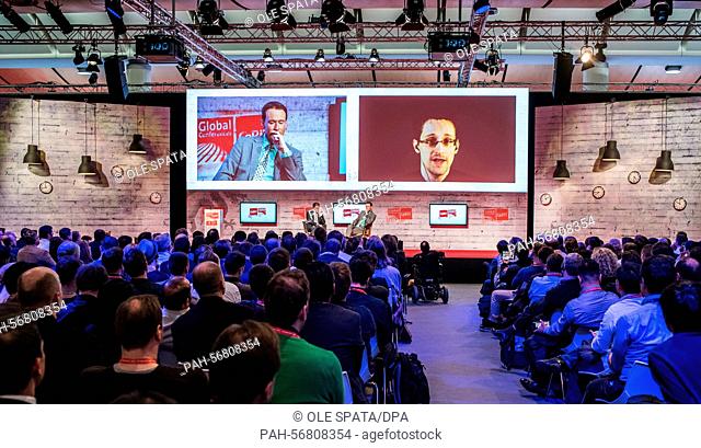 A video screen shows a transmittion of US whistleblower Edward Snowden (R) and journalist Brent Goff (L), in attendance of journalist Glenn Greenwald (on stage
