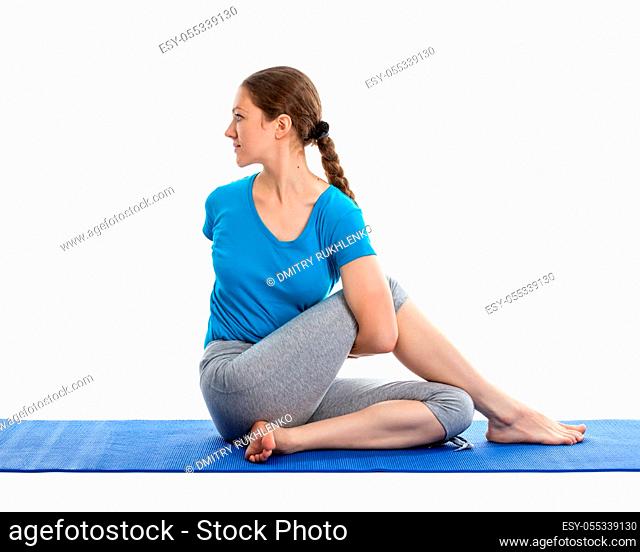 Yoga - young beautiful woman yoga instructor doing Half Spinal Twist Pose (or Half Lord of the Fishes Pose - ardha matsyendrasana) exercise isolated on white...