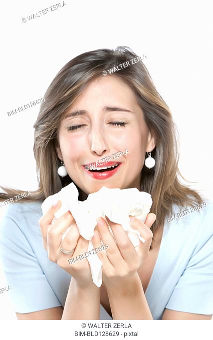 Woman sneezing into tissues