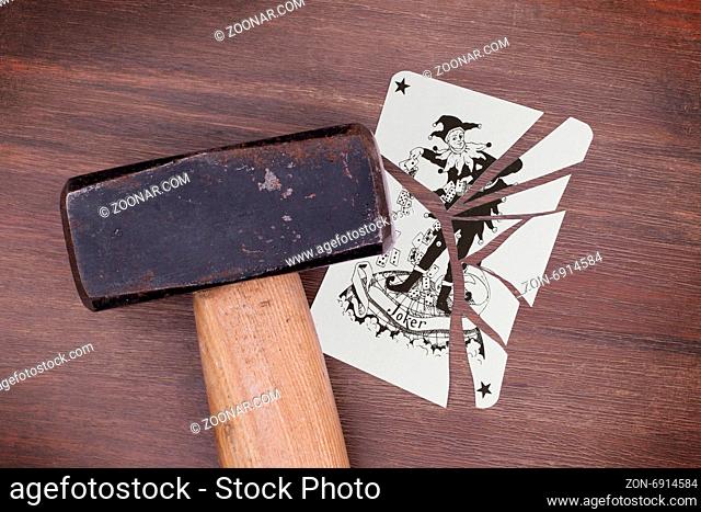 Hammer with a broken card, vintage look, joker